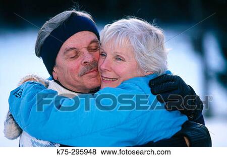 Stock Photo - Mature couple hugging outside in the winter. Fotosearch