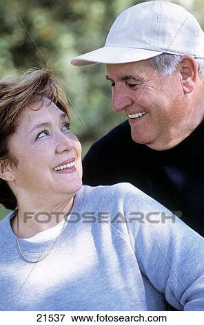 Stock Photo - Mature couple in sport outfit looking at each other and smiling. Fotosearch