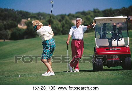 Stock Image - Mature couple playing golf. Fotosearch