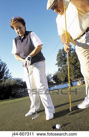 Stock Image - Mature couple playing golf. Fotosearch