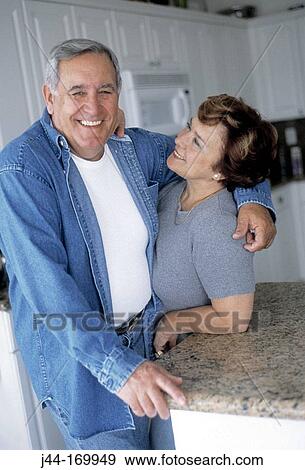 Mature couple sharing a moment in the kitchen View Large Photo Image Stock Photo - Mature couple sharing a moment in the kitchen. Fotosearch