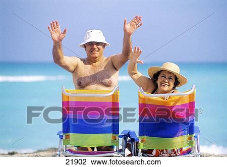 Mature couple sitting on beach chairs at the beach View Large Photo Image Stock Image - Mature couple sitting on beach chairs at the beach. Fotosearch