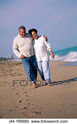 Stock Image - Mature couple walking at the beach. Florida. USA. Fotosearch