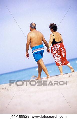 Stock Photo - Mature couple walking at the beach, Florida, USA. Fotosearch