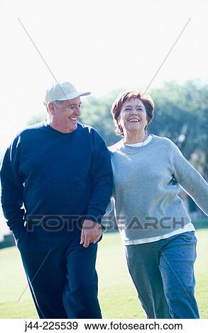 Mature couple walking in the park View Large Photo Image Stock Photo - Mature couple walking in the park. Fotosearch