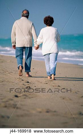 Mature couple walking on the beach View Large Photo Image Stock Photo - Mature couple walking on the beach. Fotosearch