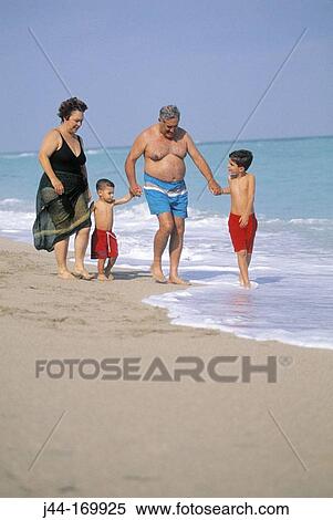 Mature couple with grandchildren walking at the beach, Florida, USA View Large Photo Image Stock Photography - Mature couple with grandchildren walking at the beach, Florida, USA. Fotosearch