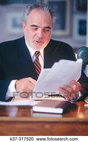 Stock Image - Mature executive businessman at desk. Fotosearch
