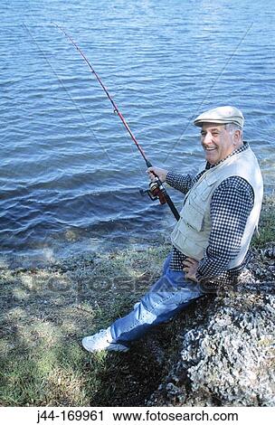 Stock Image - Mature man fishing in a lake, Florida, USA. Fotosearch