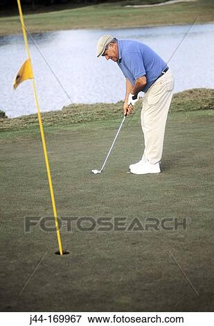 Mature man playing golf on the green View Large Photo Image Stock Photo - Mature man playing golf on the green. Fotosearch