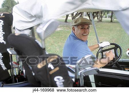 Mature man riding a golf cart View Large Photo Image Stock Photo - Mature man riding a golf cart. Fotosearch