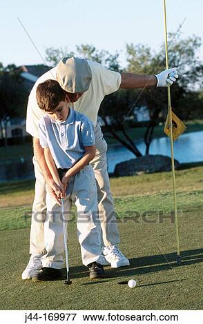 Mature man teaching boy to play golf View Large Photo Image Stock Photo - Mature man teaching boy to play golf. Fotosearch