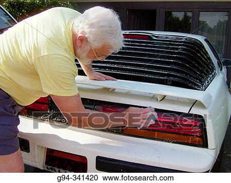 Stock Image - Mature man washes his car. Fotosearch