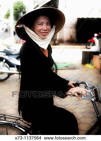 Picture - Mature woman on bicycle, Vietnam. Fotosearch