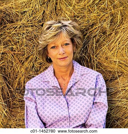 Mature woman portrait against bale of hay View Large Photo Image Stock Image - Mature woman portrait against bale of hay. Fotosearch