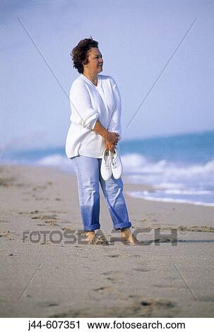 Mature woman standing at the beach wearing cloths View Large Photo Image Stock Image - Mature woman standing at the beach wearing cloths. Fotosearch