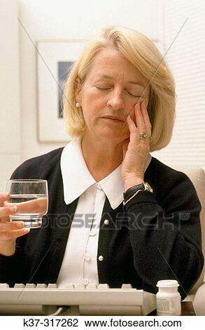 Mature woman with glass of water, suffering from headache View Large Photo Image Stock Image - Mature woman with glass of water, suffering from headache. Fotosearch