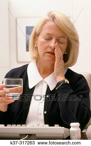 Mature woman with glass of water, suffering from headache View Large Photo Image Stock Image - Mature woman with glass of water, suffering from headache. Fotosearch