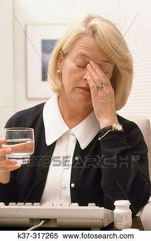 Mature woman with glass of water, suffering from headache View Large Photo Image Stock Photography - Mature woman with glass of water, suffering from headache. Fotosearch