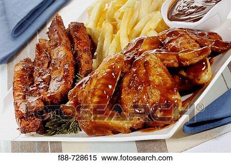 Meat platter with marinated chicken wings and ribs with sauce and chips, food View Large Photo Image Stock Photography - Meat platter with marinated chicken wings and ribs with sauce and chips, food. Fotosearch