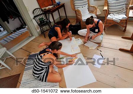 Stock Image - MEDEVI SWEDEN Young women plan seating arrangement for a wedding dinner.. Fotosearch