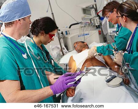 Medical staff attending to patient at hospital View Large Photo Image Stock Image - Medical staff attending to patient at hospital. Fotosearch