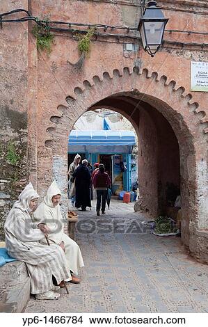 Picture - Medina with archway and traditional dressed men, Chefchaouen, Morocco. Fotosearch
