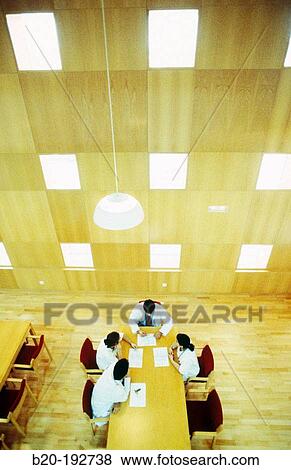 Meeting of doctors at library of hospital View Large Photo Image Stock Photo - Meeting of doctors at library of hospital. Fotosearch
