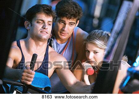 Stock Image - Men and woman in a gym. Fotosearch