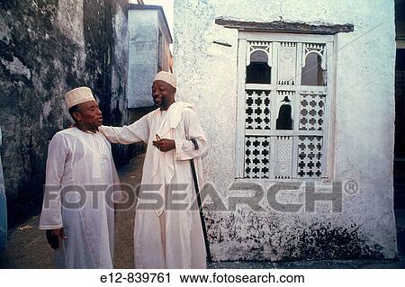 Stock Image - Men chatting before attending a great wedding, Grande Comore, Comoros. Fotosearch