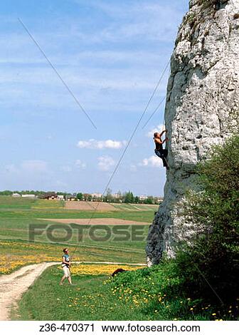 Stock Image - Men climbing on rock. Fotosearch
