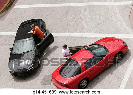 Stock Photo - Men, drivers, cars, minor auto accident, exchange information. Ocean Drive. Miami Beach, Florida. USA.. Fotosearch