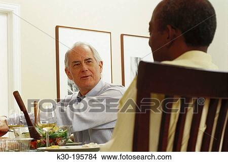 Men enjoying dinner at home View Large Photo Image Picture - Men enjoying dinner at home. Fotosearch