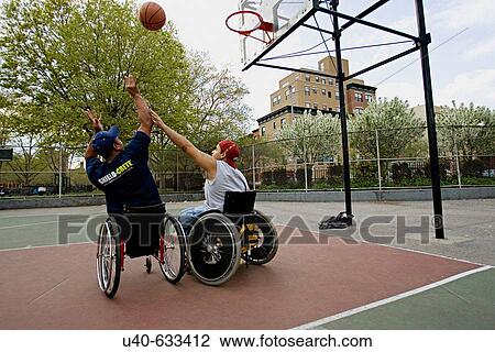 Stock Image - Men in wheelchairs playing basketball. Fotosearch