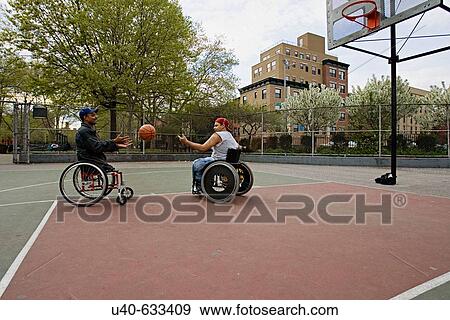 Stock Photo - Men in wheelchairs playing basketball. Fotosearch
