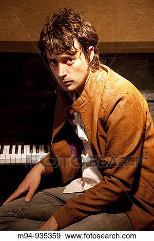 Men on a piano looking at camera View Large Photo Image Stock Photo - Men on a piano looking at camera. Fotosearch