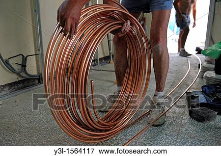 Men on work site, unwinding a copper tube, used for water network, Marseille, France View Large Photo Image Stock Photo - Men on work site, unwinding a copper tube, used for water network, Marseille, France. Fotosearch