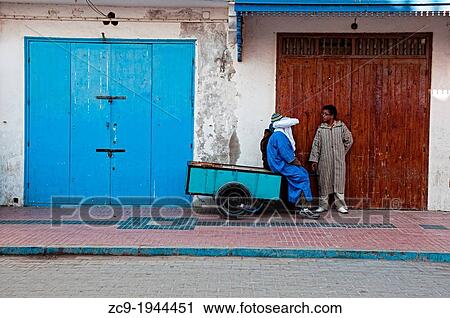 Men talking on the streets of Essaouira medina, Morocco. View Large Photo Image Stock Image - Men talking on the streets of Essaouira medina, Morocco.. Fotosearch