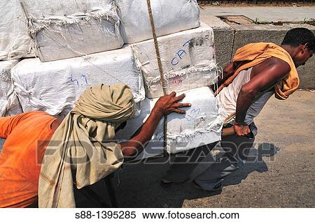 Stock Photography - Men transport heavy luggages by man power. Fotosearch