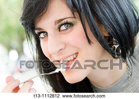 Stock Image - Messy while eating cake teenager girl portrait. Fotosearch