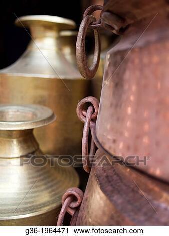 Stock Image - Metal canisters are stacked up at an outdoor market in Patan, Nepal.. Fotosearch