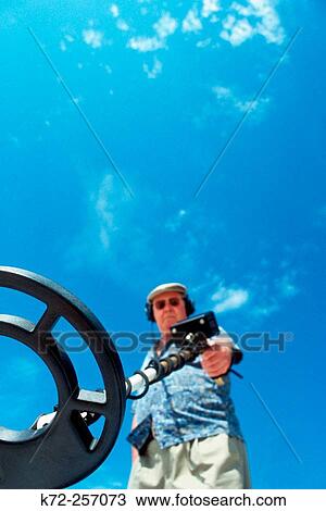 Metal detector being used at beach View Large Photo Image Stock Image - Metal detector being used at beach. Fotosearch