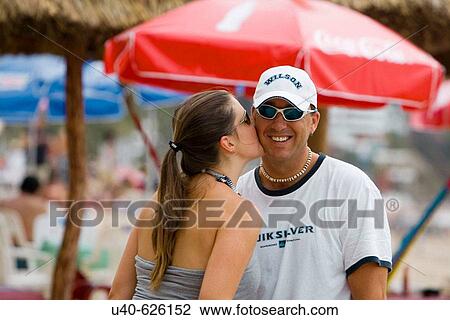 Stock Image - Mexico, Puerto Vallarta. Couple kissing on the beach.. Fotosearch