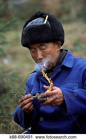 Stock Image - Miao man with pipe, Guizhou, China. Fotosearch