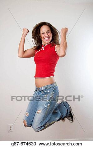Mid 20s caucasian woman jumps in excitment and celebration in a home on Los Angeles, CA, USA View Large Photo Image Stock Image - Mid 20s caucasian woman jumps in excitment and celebration in a home on Los Angeles, CA, USA. Fotosearch