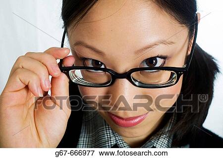 Mid 20's Chinese woman looks over the top of her glasses in studio head shot/portrait View Large Photo Image Stock Photo - Mid 20's Chinese woman looks over the top of her glasses in studio head shot/portrait. Fotosearch
