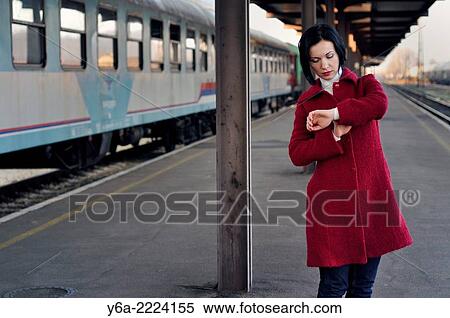 Mid adult looking at her wristwatch at the train station. View Large Photo Image Stock Photography - Mid adult looking at her wristwatch at the train station.. Fotosearch
