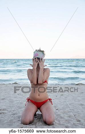 Mid adult woman in bikini kneeling on beach covering face, Alcudia, Mallorca, Spain, Europe View Large Photo Image Stock Photo - Mid adult woman in bikini kneeling on beach covering face, Alcudia, Mallorca, Spain, Europe. Fotosearch
