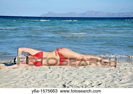 Mid adult woman sunbathing on beach, Alcudia, Mallorca, Spain, Europe View Large Photo Image Stock Image - Mid adult woman sunbathing on beach, Alcudia, Mallorca, Spain, Europe. Fotosearch