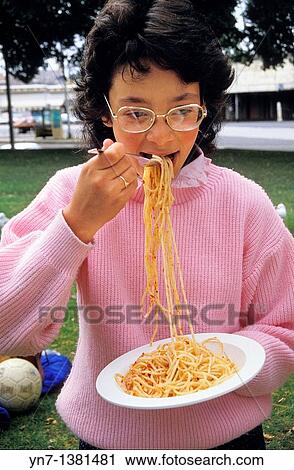 mid shot of a young girl in park obviously enjoying her bowl of spaghetti View Large Photo Image Stock Image - mid shot of a young girl in park obviously enjoying her bowl of spaghetti. Fotosearch